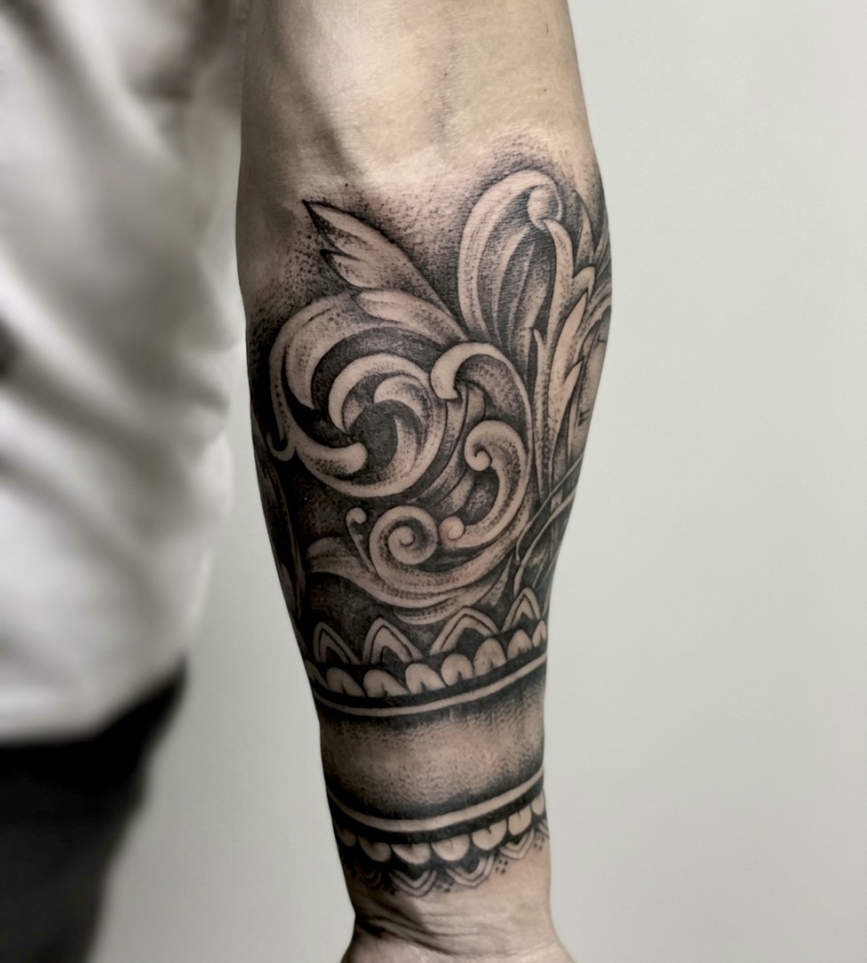 Fresh black and grey Baroque Ornamental Forearm Tattoo with scrolls and a Geometric wrist band.