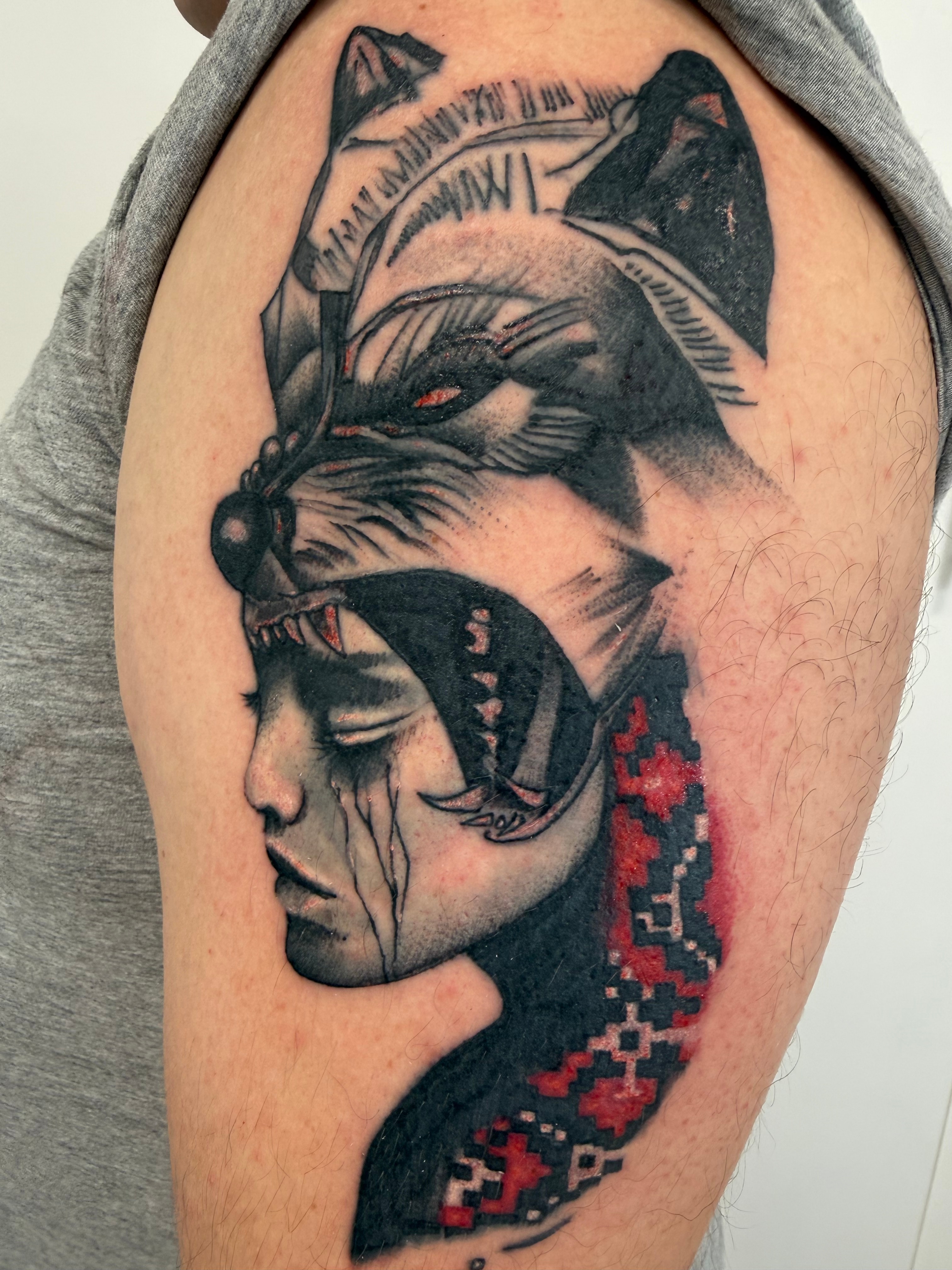 Black and grey geometric wolf tattoo on the upper arm