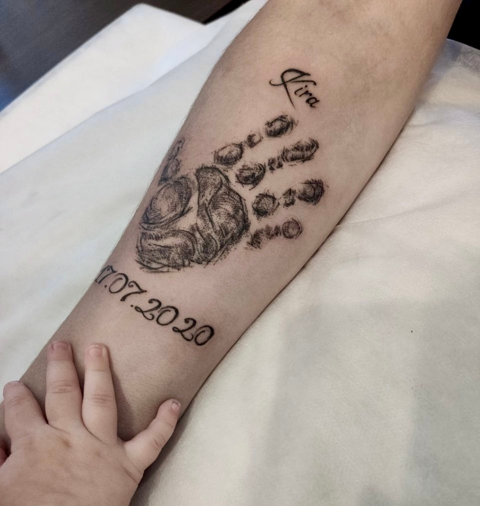 Child handprint tattoo with a name and date for one parent