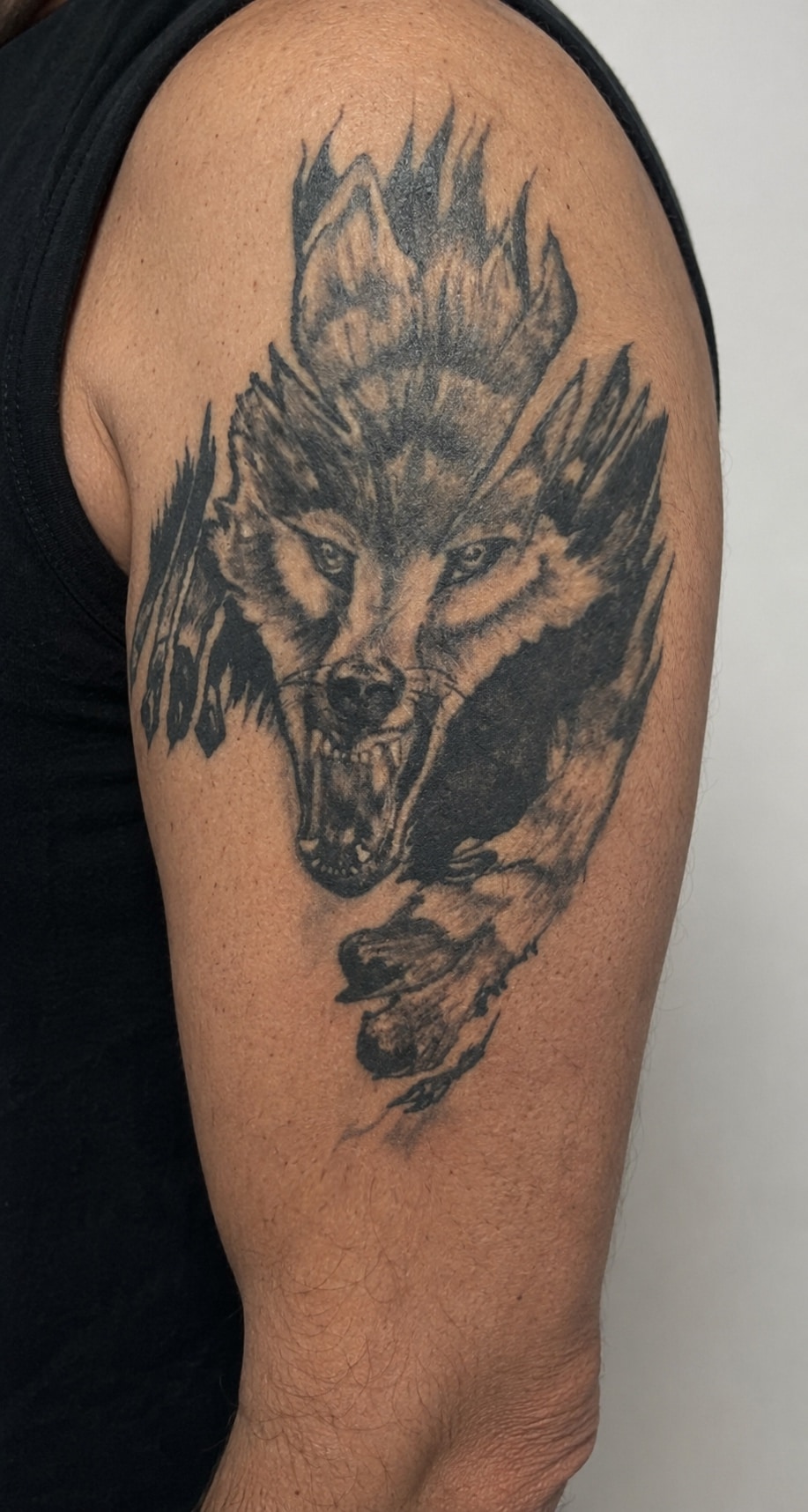 Smaller black wolf upper-arm tattoo before the Cover-Up