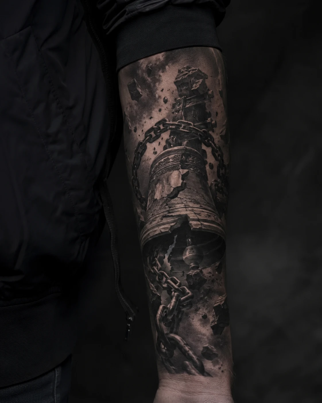 Cracked bell wrapped in heavy chains tattoo on forearm
