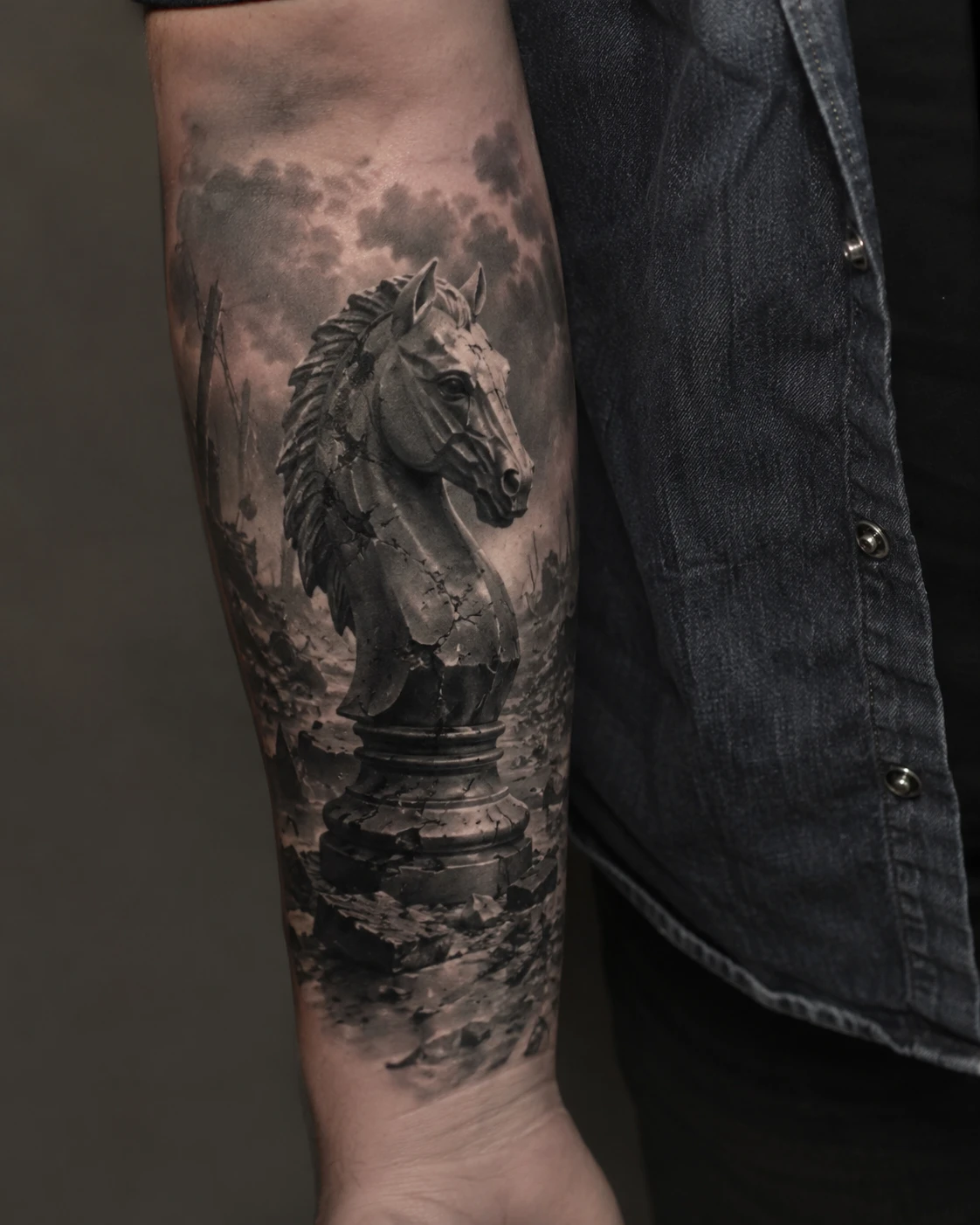 Cracked chess knight sculpture tattoo on the forearm