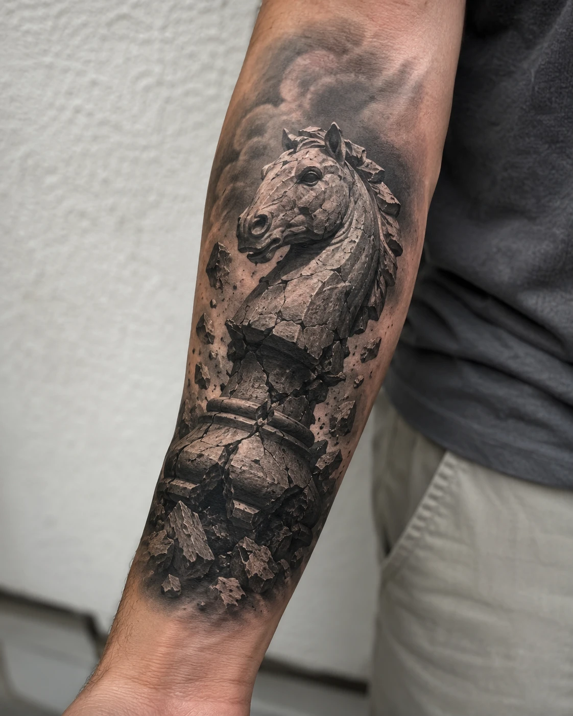 Fractured stone chess knight tattoo on the forearm