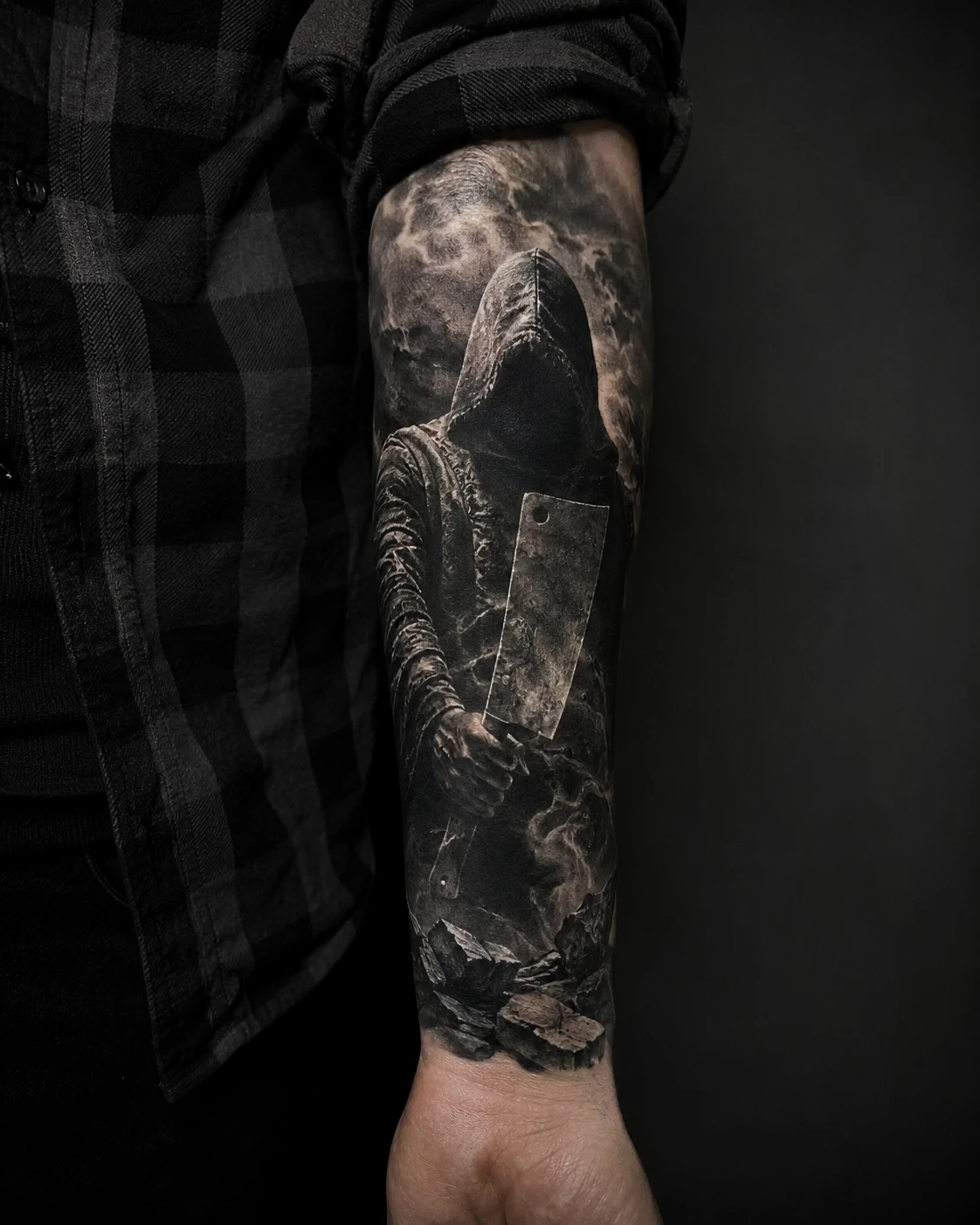 Hooded figure gripping a broad cleaver in dense black smoke.
