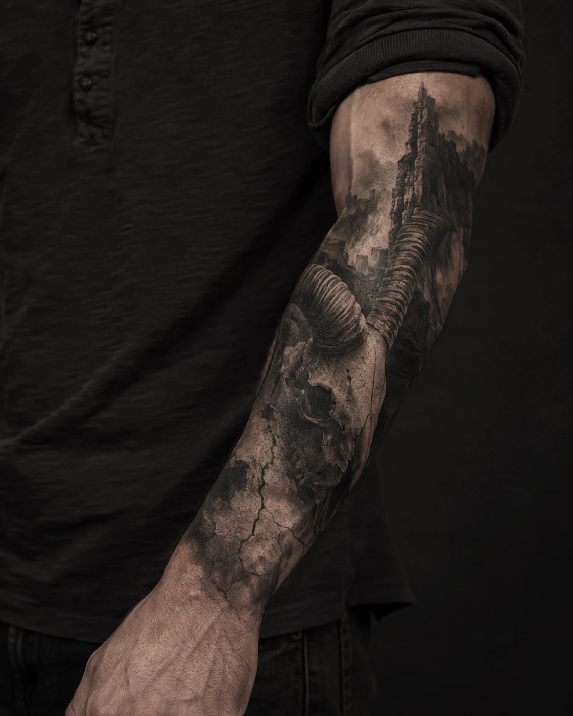 Horned skull and ruined tower tattoo on the forearm