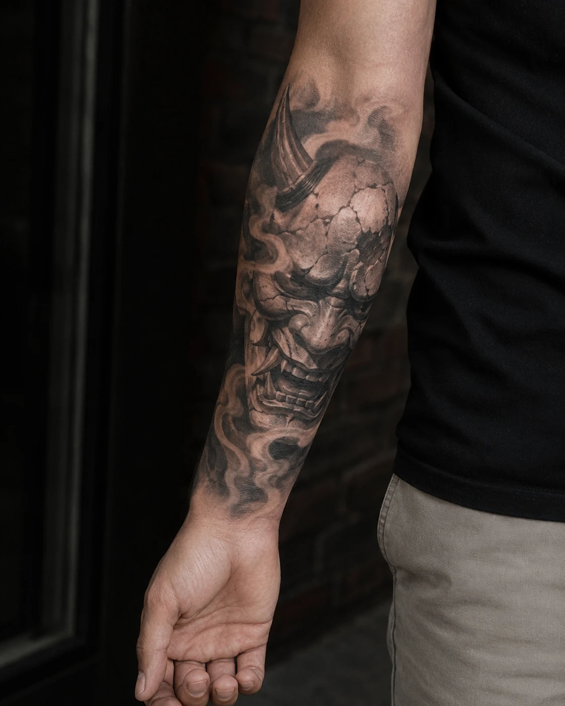Japanese oni mask tattoo surrounded by smoke on forearm