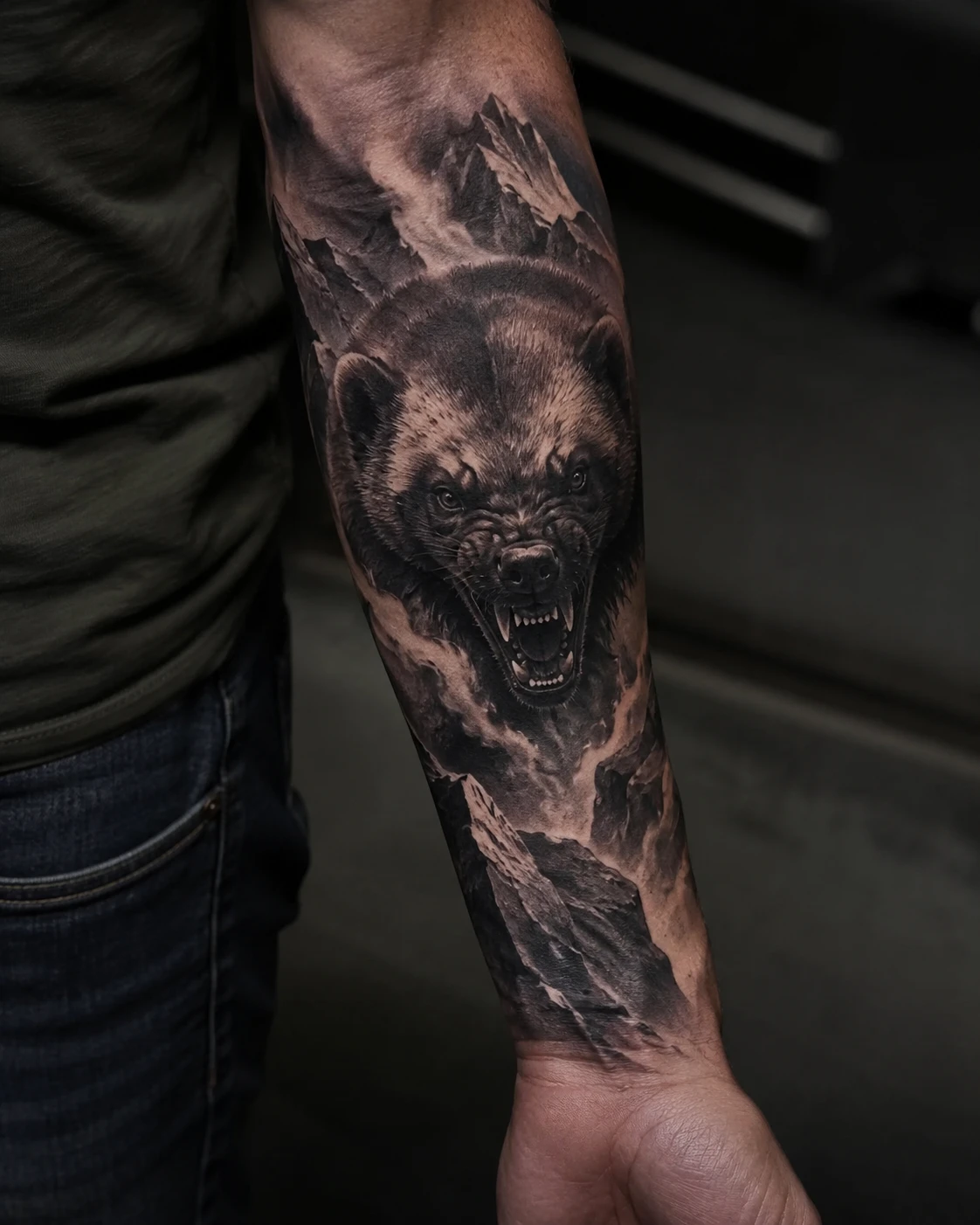 Roaring bear and mountain ridge tattoo on the forearm