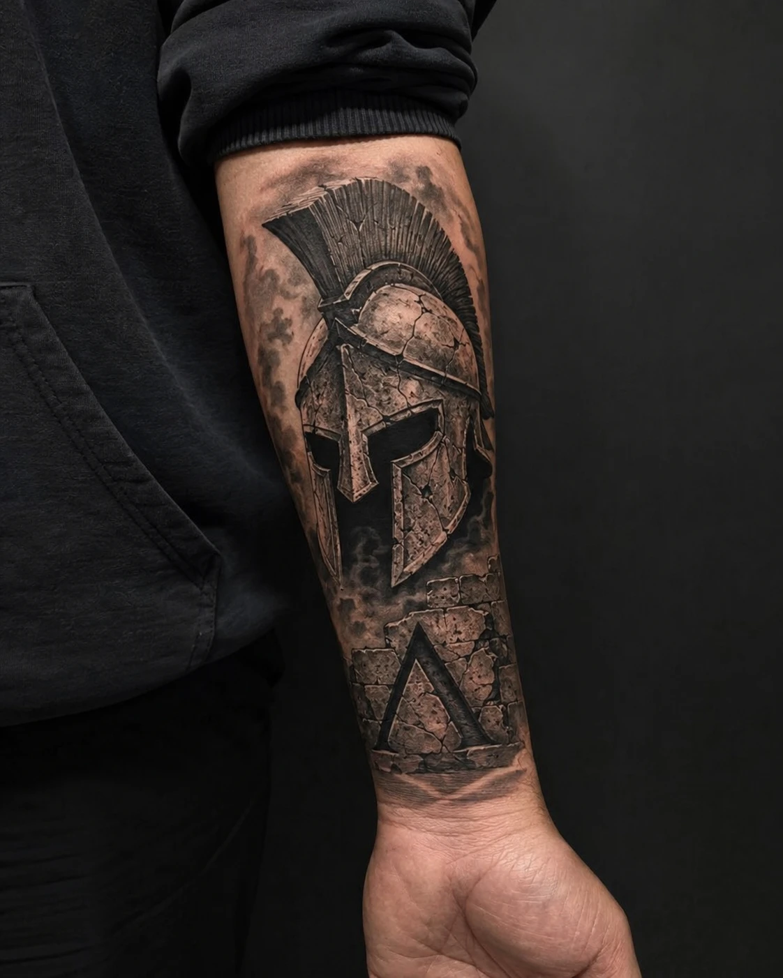 Polished Spartan helmet overlaps a lambda marked shield within balanced geometric framing.