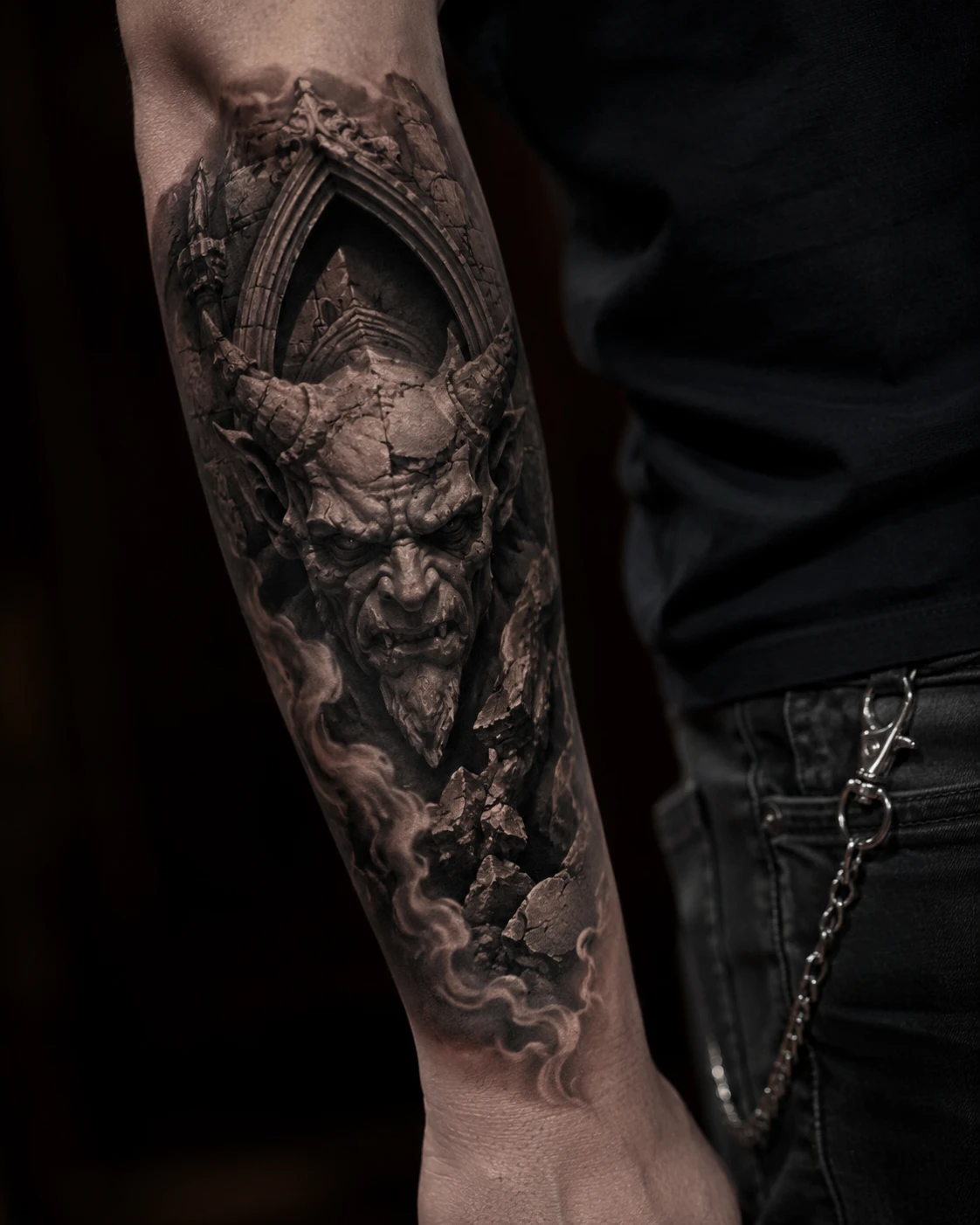 Horned stone gargoyle in Gothic arch tattoo on forearm