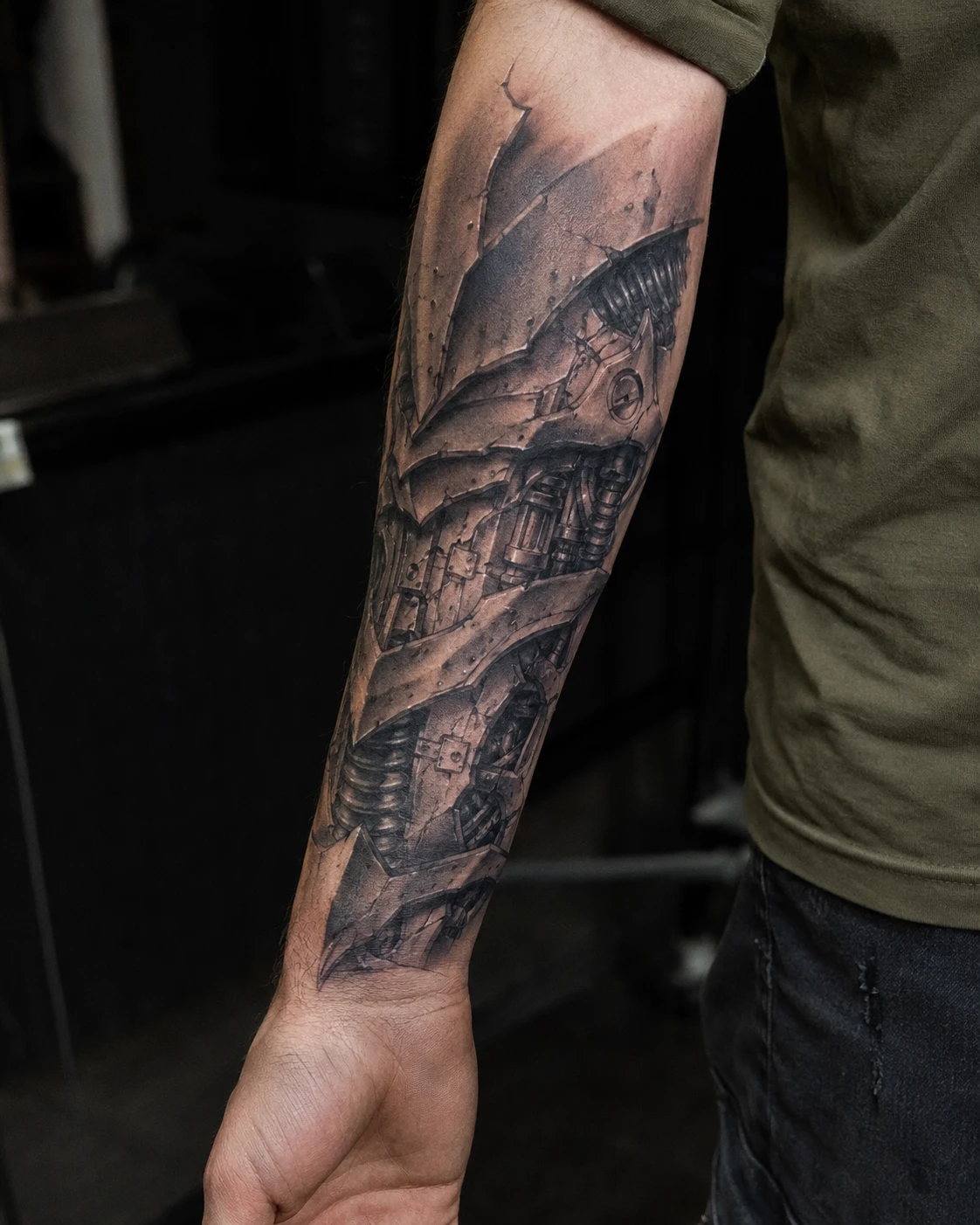Torn skin revealing dark biomechanical cables, braces and metal panels